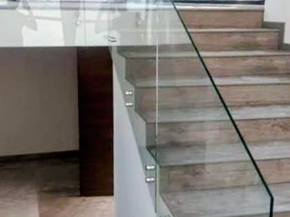 Barandal de vidrio templado en escalera con botones de acero