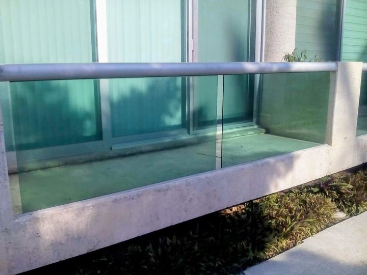 Barandal de vidrio templado en terraza con pasamanos de acero