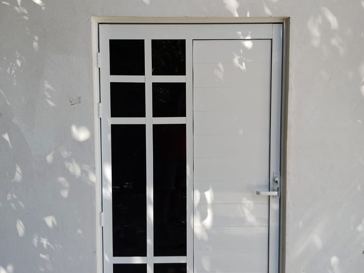 Puerta de aluminio con vidrio y cuadrícula