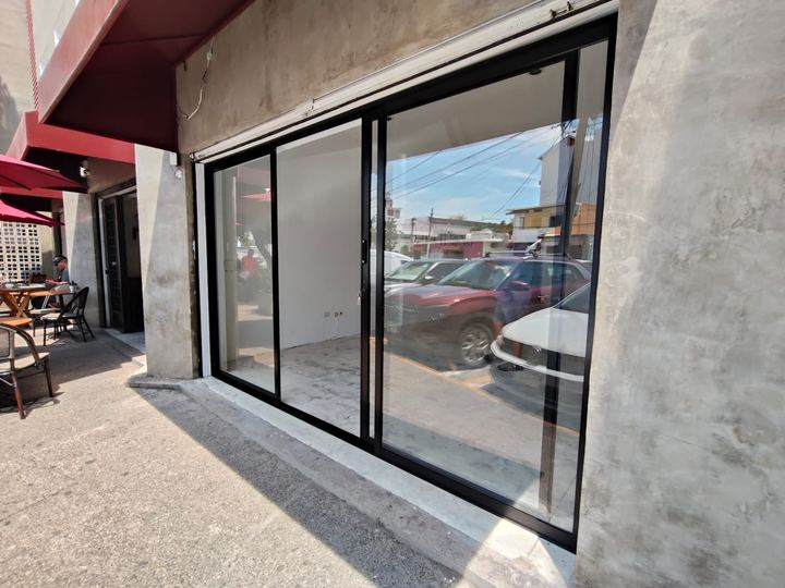 Fachada comercial con puerta corrediza de aluminio y vidrio