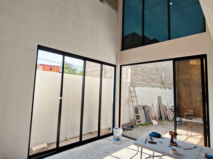 Cancelería de aluminio negro a doble altura con vidrio polarizado