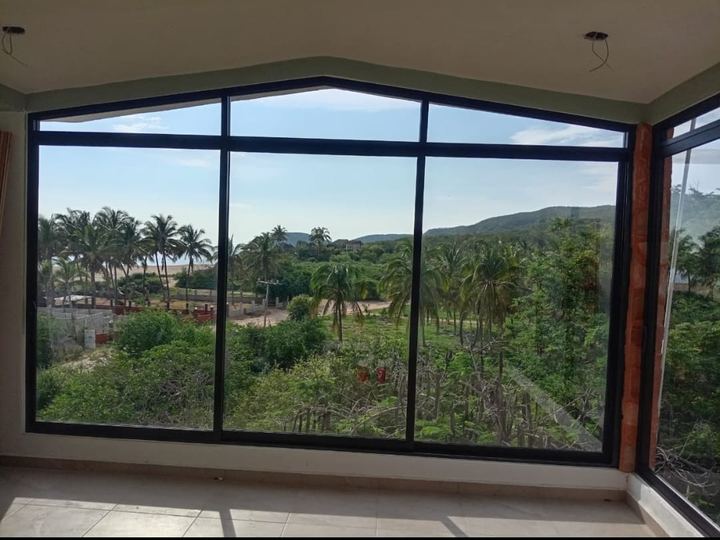 Ventanal de aluminio negro con remate superior a dos aguas