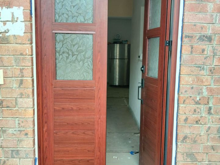 Puerta de entrada de aluminio color madera con vidrio decorado