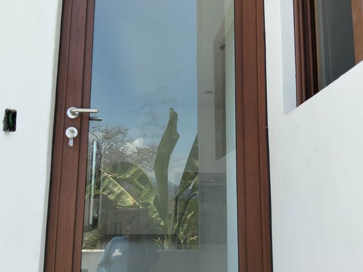 Puerta de aluminio color madera con vidrio de piso a techo
