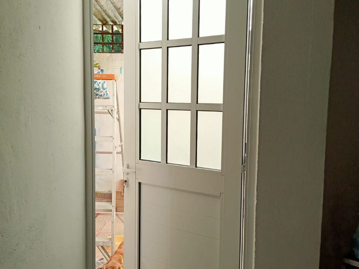 Puerta de aluminio blanco con vidrio esmerilado hacia el patio