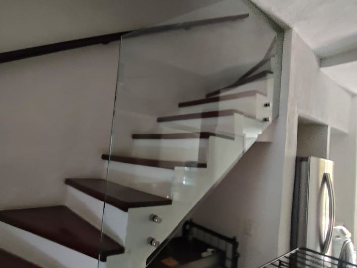 Barandal de vidrio templado en escalera con pasamanos de madera